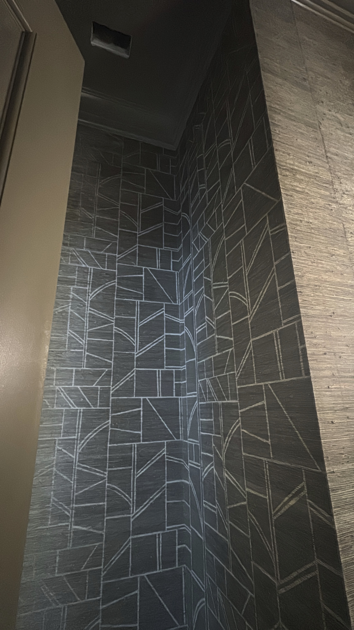 Close view of dark geometric wallcovering precisely wrapped around an interior corner
